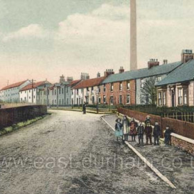South Hetton, East Front Street before 1908. This coloured print shows the view from a few yards to the east of the view in HET 014, with South Lodge(?) on the left and South View (subsequently the residence of the Mechanical Engineer) on the right.  The last of the chimneys in the background was demolished in the mid-1950s when the majority of the surface faciclities at the pit were redeveloped.  The road was surfaced with crushed rock (macadamised) until the lifetime of my father (b. 1921), when the surface was sealed with coal tar (tarmac).   Caption by Sheldon Clark